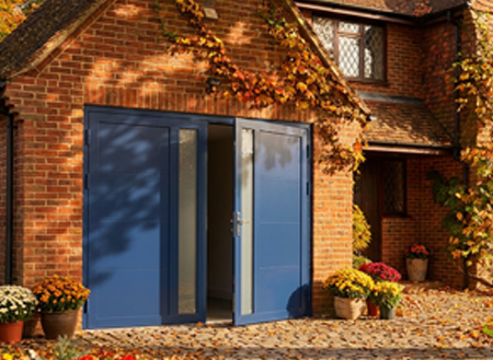 Hormann Rollmatic insulated electric roller garage door on a modern home at dusk